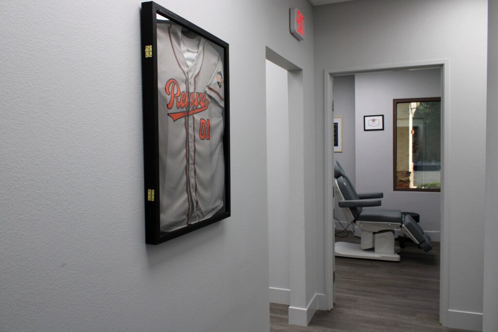 Hallway with framed Revive jersey leading to a treatment room